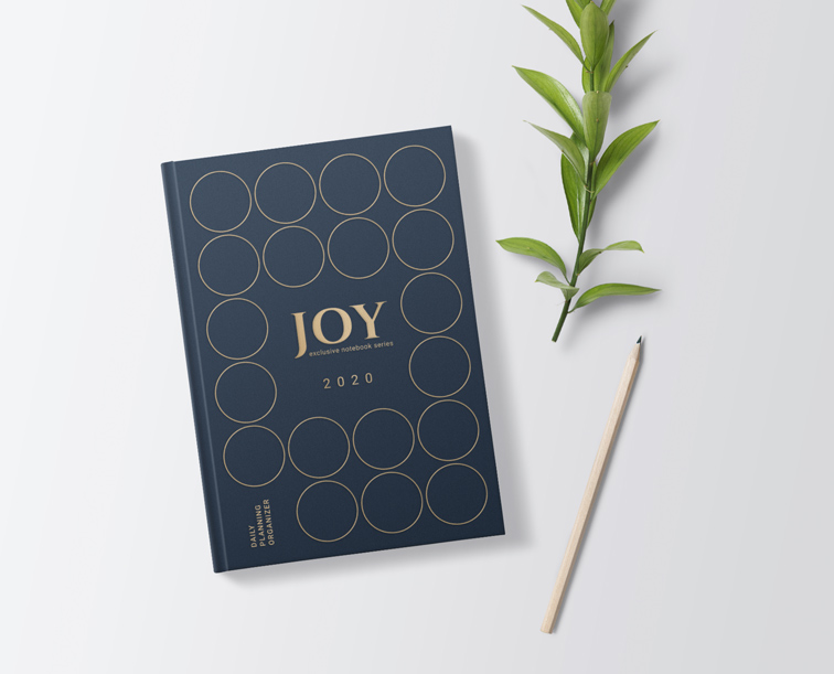 Cuadernillo de tapa dura junto a un lápiz