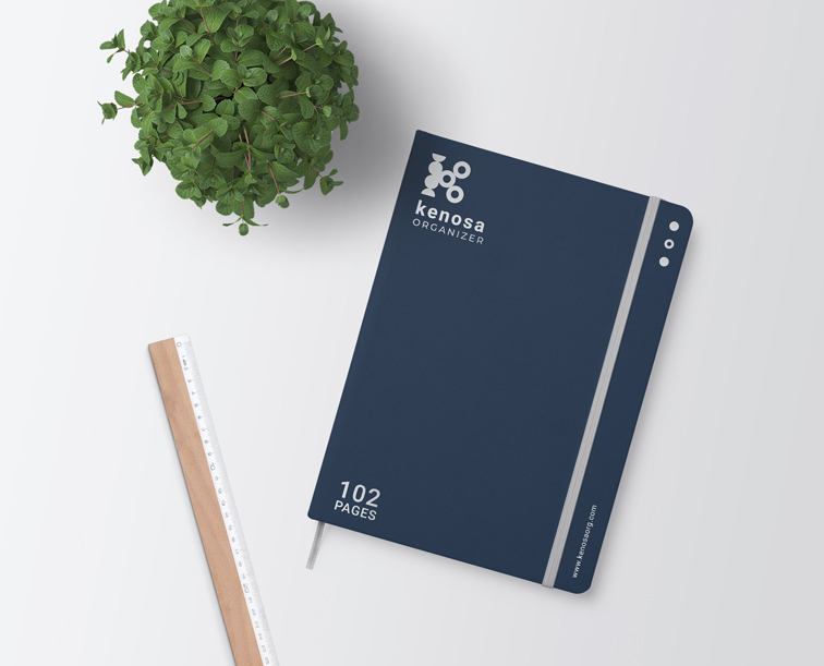 Cuaderno con elástico, una regla y una planta