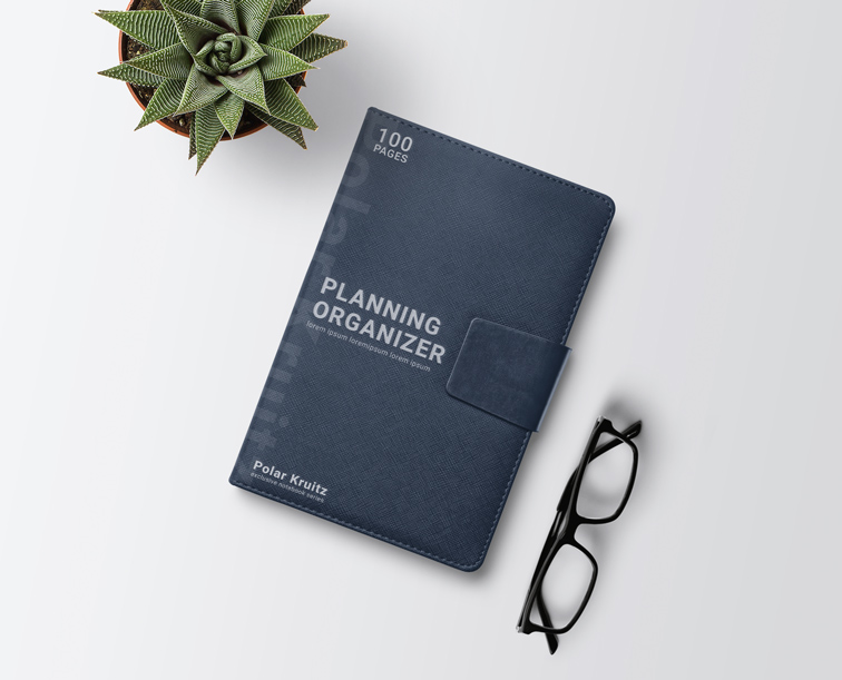 Cuadernillo de cuero junto a lentes