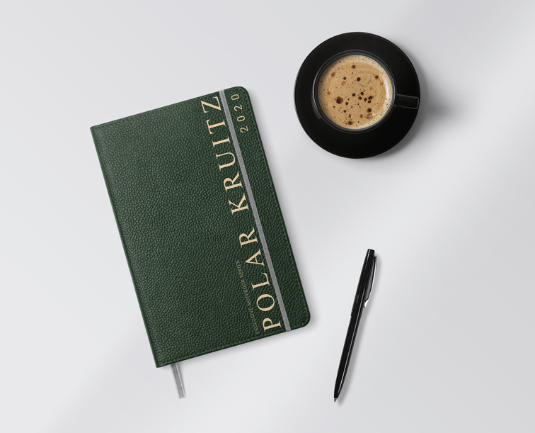 Cuadernillo de cuero, un bolígrafo y una taza de café