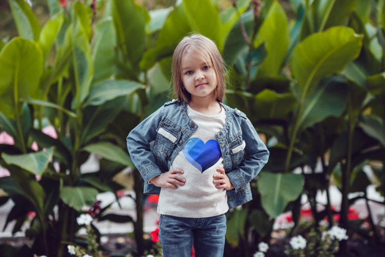 Niña con grandes plantas detrás