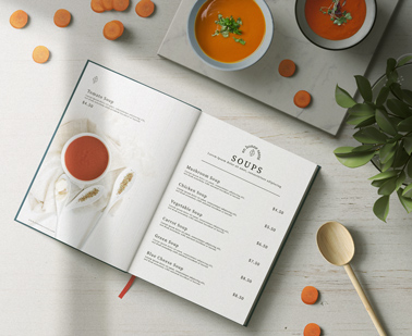 Раскрытое  меню в твердой обложке рядом с суповыми чашами