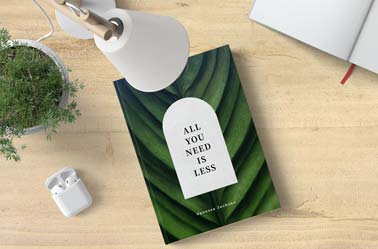Buch, AirPods und eine Schreibtischlampe