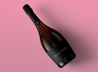 Geneigte Champagnerflasche auf einer rosa Oberfläche