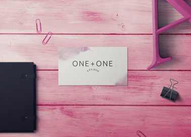 Um Cartão de Visita e Outros Artigos de Papelaria em uma Mesa