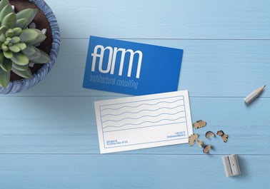 Dos tarjetas de visita junto a una planta