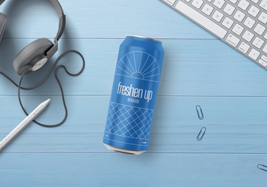 Lata de refresco junto a cabezales y un lápiz