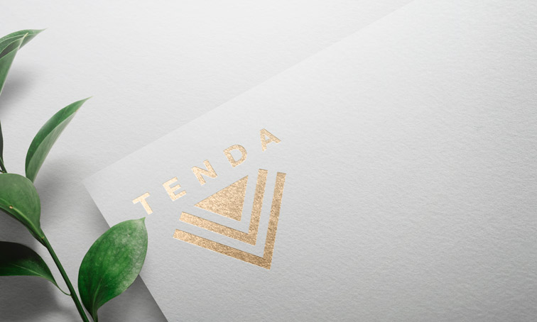 Logo sobre papel blanco junto a una planta