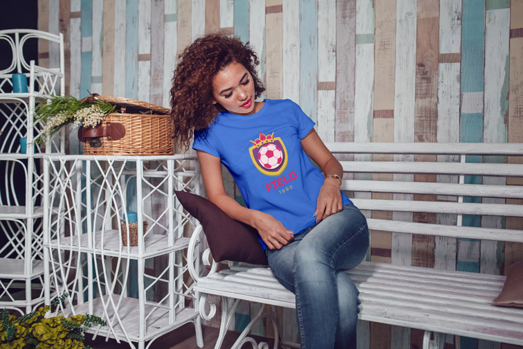 Sitzendes Mädchen, das ihr T-Shirt betrachtet
