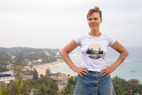 Frau im T-Shirt mit Händen auf ihren Hüften