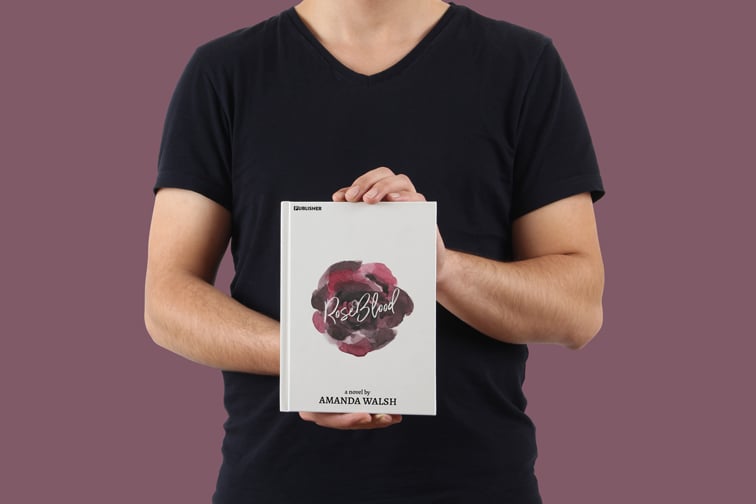 ハードカバーの本を保持している男