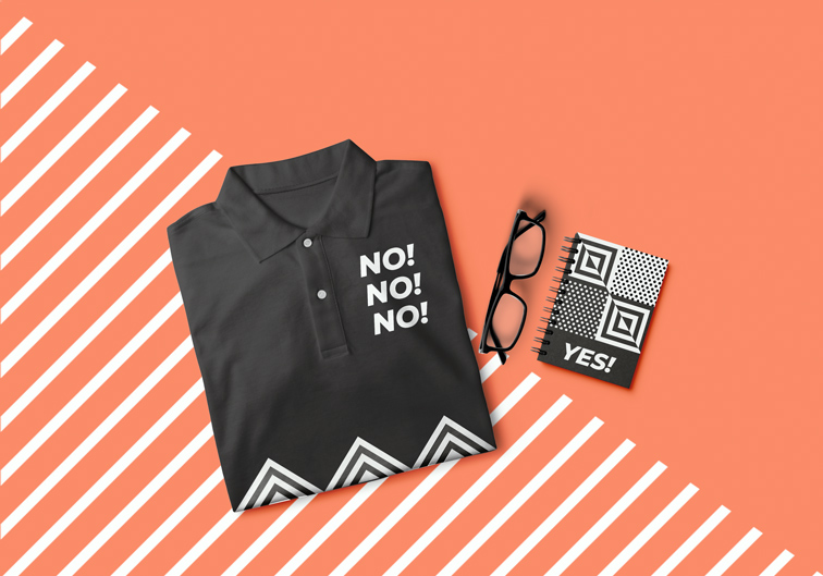 Camiseta doblada junto a un bloc de notas y unas gafas