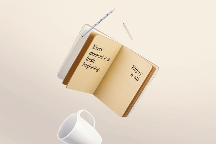 飛翔の開いているメモ帳や鉛筆、カップ