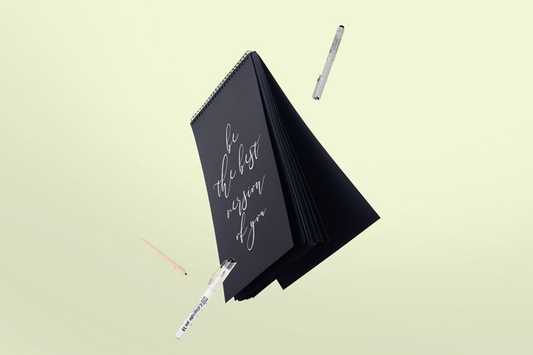 飛翔の垂直なスケッチブックやペン、鉛筆