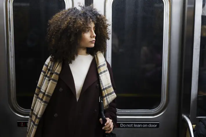 Passenger swaying on a train as tunnel lights blur past